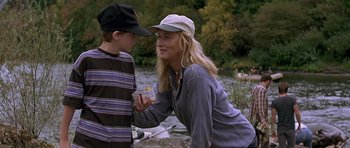 Movie still from “The River Wild” (1994), directed by Curtis Hanson – A woman and a young boy standing next to a body of water; Medium shot, Over the shoulder angle