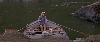 Movie still from “The River Wild” (1994), directed by Curtis Hanson – A woman and a dog in a boat on a river; Wide shot, High angle