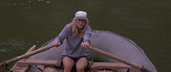 Movie still from “The River Wild” (1994), directed by Curtis Hanson – A woman rowing a boat on a river; Medium shot, High angle