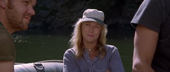 Movie still from “The River Wild” (1994), directed by Curtis Hanson – A woman wearing a hat sitting in a boat; Close Up shot, Over the shoulder angle