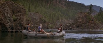 Movie still from “The River Wild” (1994), directed by Curtis Hanson – A group of people in a boat on a river; Wide shot, High angle