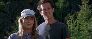 Movie still from “The River Wild” (1994), directed by Curtis Hanson – A man and a woman posing for a picture; Close Up shot, Low angle