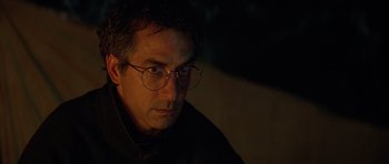 Movie still from “The River Wild” (1994), directed by Curtis Hanson – A person wearing glasses and a black shirt; Close Up shot, Over the shoulder angle