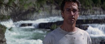 Movie still from “The River Wild” (1994), directed by Curtis Hanson – A person wearing glasses near a waterfall; Close Up shot, Low angle