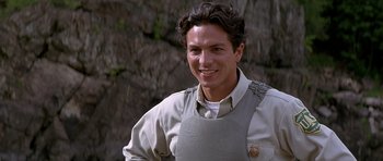 Movie still from “The River Wild” (1994), directed by Curtis Hanson – A man wearing an aprons smiling for the camera; Close Up shot, High angle