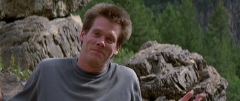Movie still from “The River Wild” (1994), directed by Curtis Hanson – A person wearing a sweater near rocks; Close Up shot, Low angle