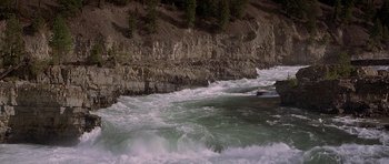 Movie still from “The River Wild” (1994), directed by Curtis Hanson – A body of water near a rocky cliff; Extreme Wide shot, High angle