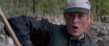 Movie still from “The River Wild” (1994), directed by Curtis Hanson – A woman in a hat and jacket is pointing at the camera; Close Up shot, Low angle