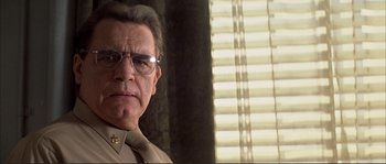 Movie still from “The Rookie” (2002), directed by John Lee Hancock – A person wearing glasses and a uniform; Close Up shot, Low angle