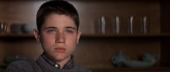 Movie still from “The Rookie” (2002), directed by John Lee Hancock – A young boy is looking into the camera; Close Up shot, Low angle