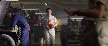 Movie still from “The Rookie” (2002), directed by John Lee Hancock – A young baseball player holding an orange frisbee; Wide shot, Low angle