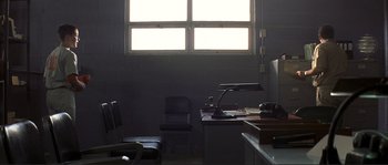 Movie still from “The Rookie” (2002), directed by John Lee Hancock – A room with a desk , chair , and a window; Wide shot, Low angle