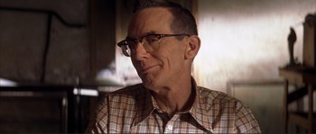 Movie still from “The Rookie” (2002), directed by John Lee Hancock – An older man wearing glasses and a plaid shirt; Close Up shot, Low angle