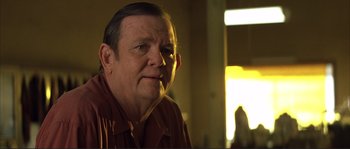 Movie still from “The Rookie” (2002), directed by John Lee Hancock – An older man in a brown shirt is looking at the camera; Close Up shot, Over the shoulder angle