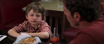 Movie still from “The Rookie” (2002), directed by John Lee Hancock – A man sitting at a table with a child; Close Up shot, Over the shoulder angle