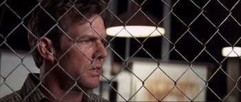 Movie still from “The Rookie” (2002), directed by John Lee Hancock – A person behind a chain link fence; Close Up shot, Low angle