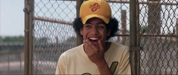 Movie still from “The Rookie” (2002), directed by John Lee Hancock – A young man with a baseball cap is smiling; Close Up shot, Low angle