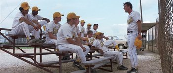 Movie still from “The Rookie” (2002), directed by John Lee Hancock – A group of baseball players sitting on top of a bench; Wide shot, Over the shoulder angle