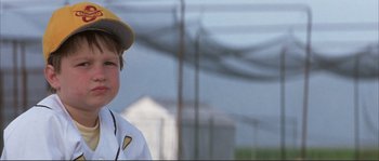 Movie still from “The Rookie” (2002), directed by John Lee Hancock – A young boy wearing a baseball uniform and a hat; Close Up shot, Low angle