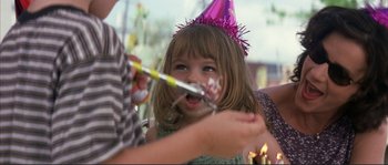 Movie still from “The Rookie” (2002), directed by John Lee Hancock – A little girl with a party hat on and a birthday cake in her mouth; Close Up shot, Over the shoulder angle