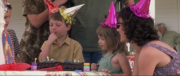 Movie still from “The Rookie” (2002), directed by John Lee Hancock – A group of children sitting around a table with a cake on it; Medium shot, Over the shoulder angle