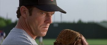 Movie still from “The Rookie” (2002), directed by John Lee Hancock – A man with a baseball glove on a baseball field; Close Up shot, Over the shoulder angle