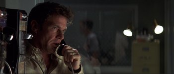 Movie still from “The Rookie” (2002), directed by John Lee Hancock – A man talking on a cell phone in a dark room; Close Up shot, Low angle