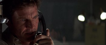 Movie still from “The Rookie” (2002), directed by John Lee Hancock – A man talking on a phone while holding it to his ear; Close Up shot, Low angle