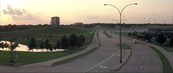 Movie still from “The Rookie” (2002), directed by John Lee Hancock – An empty road with a view of a park; Extreme Wide shot, High angle