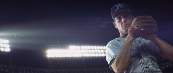 Movie still from “The Rookie” (2002), directed by John Lee Hancock – A baseball player is holding a ball in his hand; Medium shot, Low angle