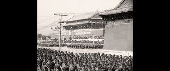 Movie still from “The Sacrifice” (2020), directed by Yang Lu – A large group of people in uniform standing next to each other in front of a building; Extreme Wide shot, High angle