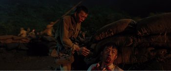 Movie still from “The Sacrifice” (2020), directed by Yang Lu – Two men in military fatigues with blood on their faces; Medium shot, High angle