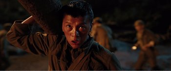 Movie still from “The Sacrifice” (2020), directed by Yang Lu – A young man in a military uniform looking into the camera; Close Up shot, Low angle