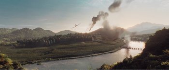 Movie still from “The Sacrifice” (2020), directed by Yang Lu – An airplane flying over a body of water with smoke billowing from it; Extreme Wide shot, High angle