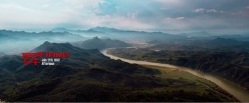Movie still from “The Sacrifice” (2020), directed by Yang Lu – A view of a river flowing through a lush green valley; Extreme Wide shot, High angle