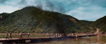 Movie still from “The Sacrifice” (2020), directed by Yang Lu – A group of people standing next to a body of water; Extreme Wide shot, High angle