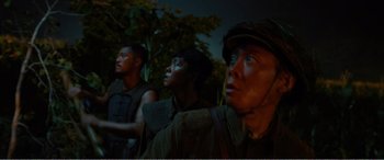 Movie still from “The Sacrifice” (2020), directed by Yang Lu – A group of men standing next to each other; Medium shot, Low angle