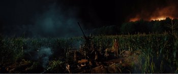 Movie still from “The Sacrifice” (2020), directed by Yang Lu – A man standing next to a field of corn at night; Extreme Wide shot, High angle