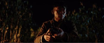 Movie still from “The Sacrifice” (2020), directed by Yang Lu – A man holding a gun in his hands; Close Up shot, Low angle