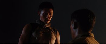 Movie still from “The Sacrifice” (2020), directed by Yang Lu – A man with a bandage on his face is talking to another man; Close Up shot, Over the shoulder angle