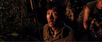 Movie still from “The Sacrifice” (2020), directed by Yang Lu – A young man in a dark place looking at the camera; Close Up shot, High angle