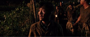 Movie still from “The Sacrifice” (2020), directed by Yang Lu – A man in a military uniform looking up at the sky; Close Up shot, Over the shoulder angle