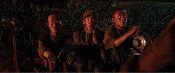 Movie still from “The Sacrifice” (2020), directed by Yang Lu – A group of men sitting next to each other on a bench; Medium shot, High angle