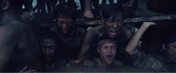 Movie still from “The Sacrifice” (2020), directed by Yang Lu – A group of young men are crying in the mud; Close Up shot, High angle