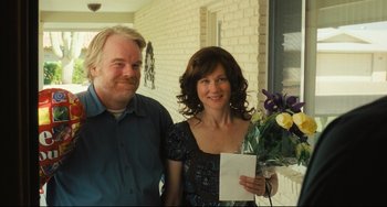Movie still from “The Savages” (2007), directed by Tamara Jenkins – A man and a woman standing next to each other holding flowers; Medium shot, Over the shoulder angle