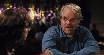Movie still from “The Savages” (2007), directed by Tamara Jenkins – A man sitting at a table with a woman; Close Up shot, Over the shoulder angle