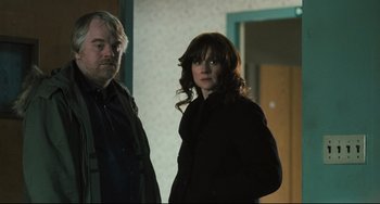 Movie still from “The Savages” (2007), directed by Tamara Jenkins – A man and a woman standing next to each other in a room; Medium shot, Over the shoulder angle