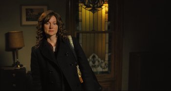 Movie still from “The Savages” (2007), directed by Tamara Jenkins – A woman standing in front of a stained glass window; Medium shot, Over the shoulder angle