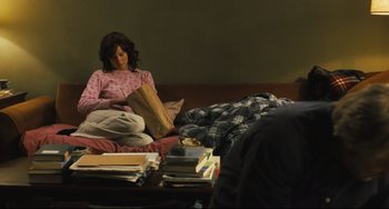 Movie still from “The Savages” (2007), directed by Tamara Jenkins – A woman sitting on a bed reading a book; Medium shot, High angle