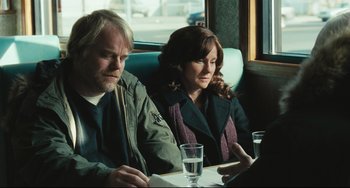 Movie still from “The Savages” (2007), directed by Tamara Jenkins – A man and a woman sitting next to each other on a bus; Medium shot, Over the shoulder angle